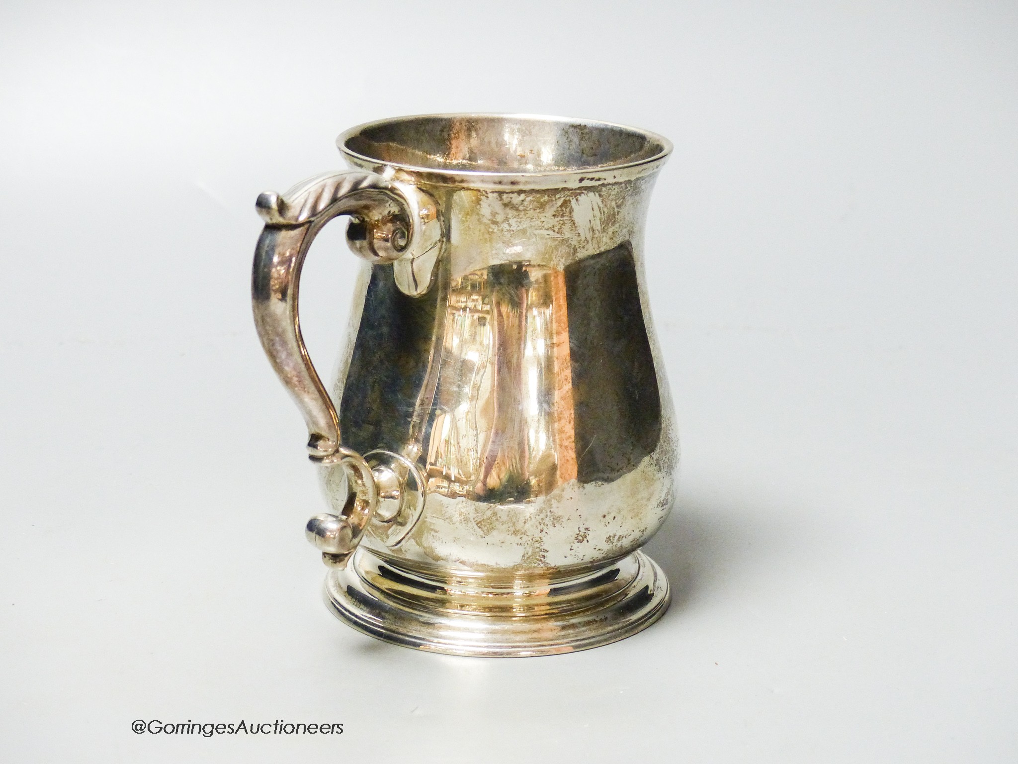 A George II silver baluster mug, with acanthus leaf capped handled and engraved crest, Henry Brind, London, 1743, height 11.7cm, 11.5oz.